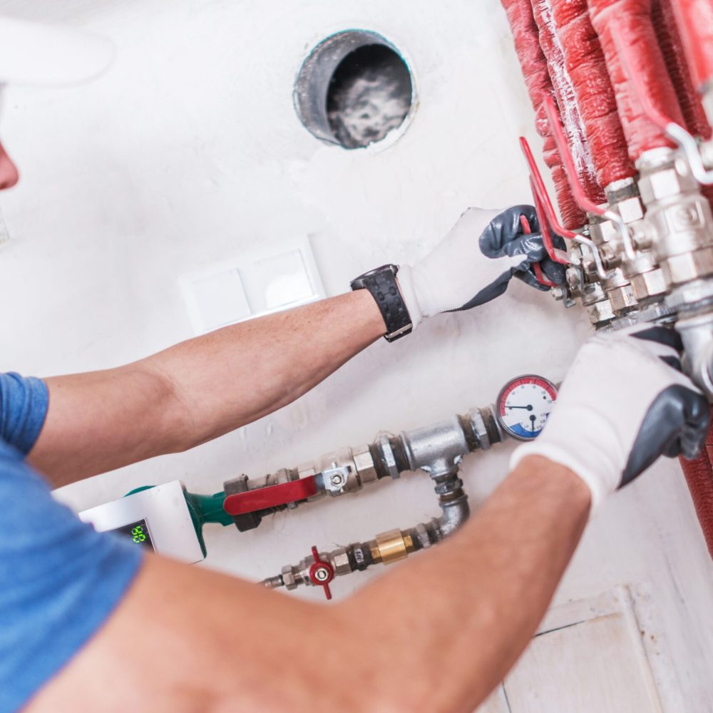 Professional Plumber Work. Caucasian Worker Checking on Water Valves.