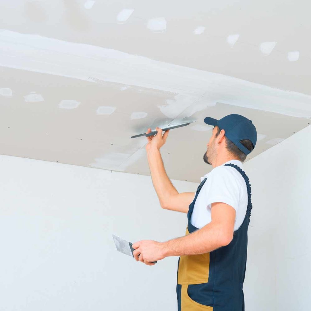 homeguide-drywall-contractor-applying-joint-compound-to-install-drywall-ceiling