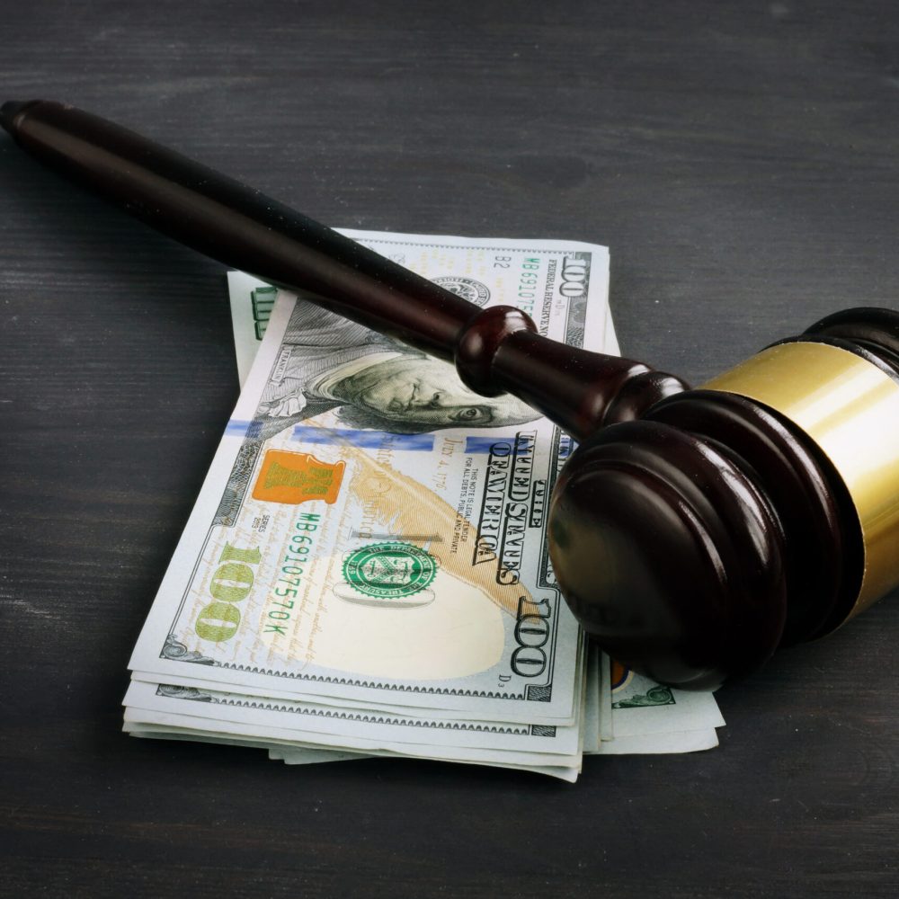 Gavel and money in the court. Penalty or bribe.